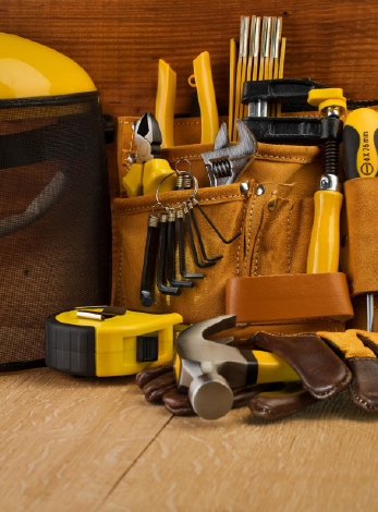 une trousse à outils, des clés, des pinces, un mètre, un marteau et des gants