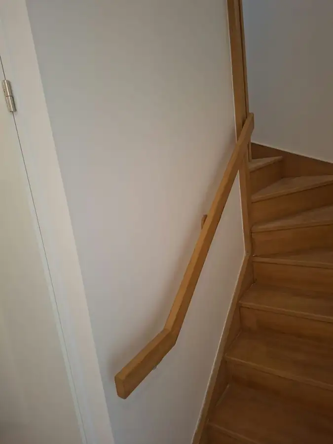 Main courante en bois posée le long d’un escalier intérieur