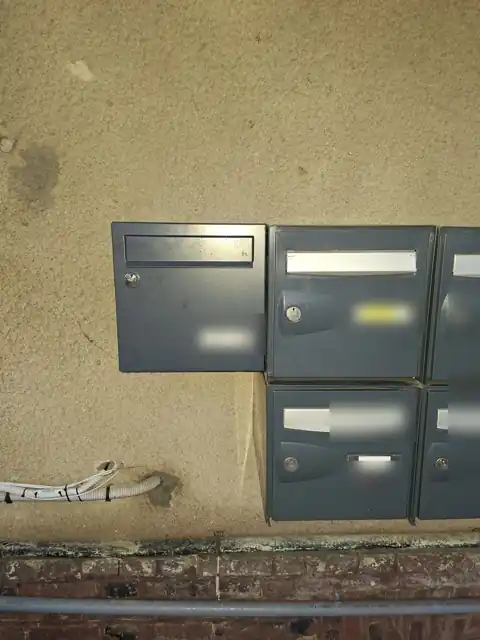 Boîte aux lettres neuve posée à côté d’un ensemble existant, étiquettes floutées