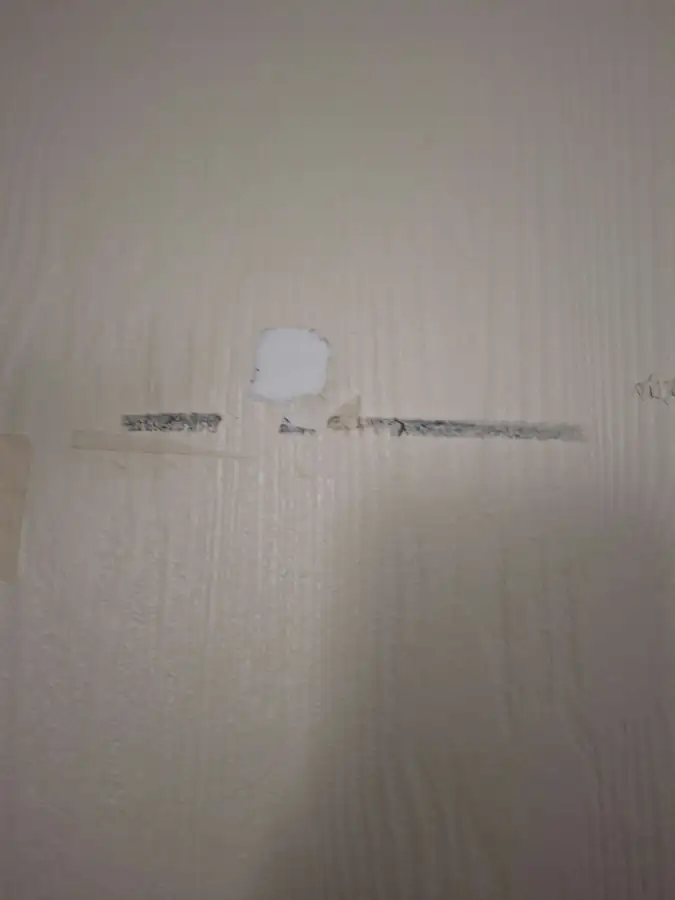 Trou rebouché dans le mur d’un couloir de parties communes