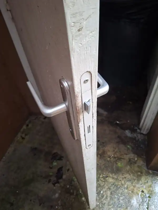 Nouvelle béquille et nouvelle serrure posées sur la porte du local à déchets